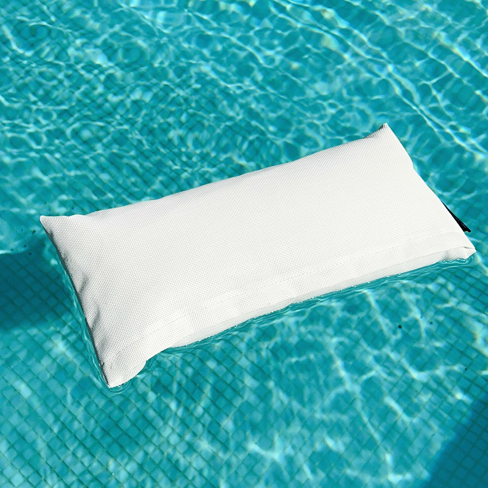 Schwimmendes KIKO-Nackenkissen in Weiß im Pool – perfekt als komfortables, wasserfestes Badekissen für Pool oder Whirlpool
