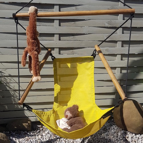 Wetterfester Hängesessel für Kinder in leuchtendem Gelb mit Plüschtieren, perfekt für Terrasse, Balkon oder Spielbereich im Freien